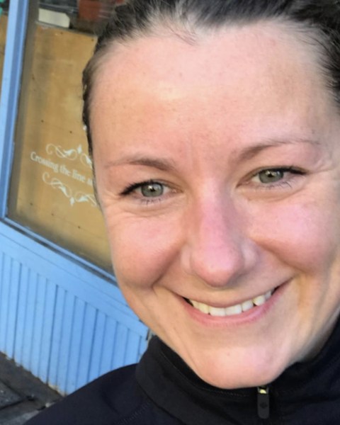Lauren smiling outside a yoga studio